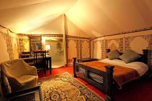 1 dormitorio con 1 cama y un escritorio en una tienda de campaña en Bhadrawati - A Riverside Safari Lodge Ranthambore, en Sawāi Mādhopur