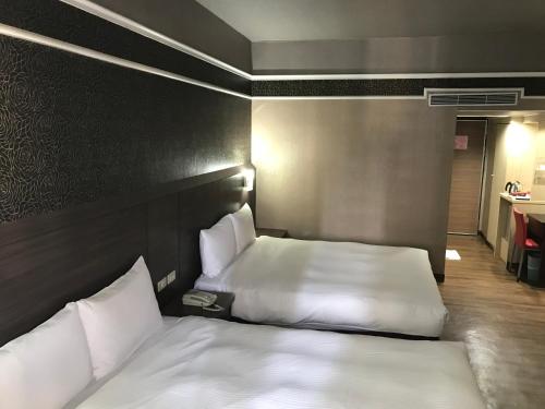 a hotel room with two beds in a room at Long Siang Hotel in Kaohsiung