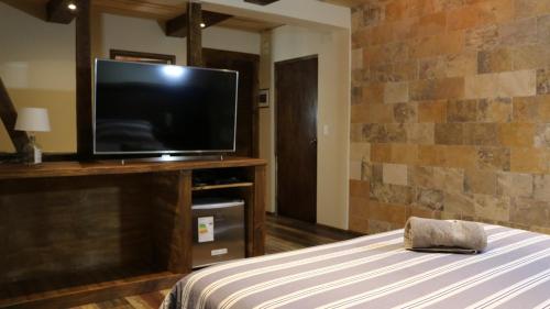 a bedroom with a flat screen tv and a bed at La Petite France in San José de Maipo