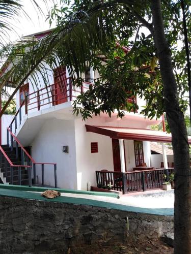 a white building with a staircase in front of it at Mahee house in Hiriketiya