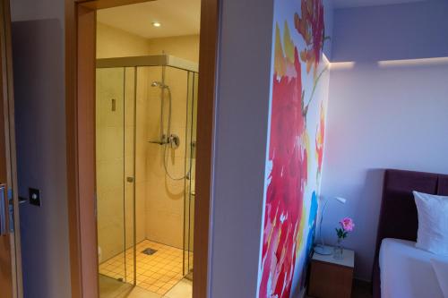 uma casa de banho com um chuveiro e uma porta de vidro em med Apart em Erlangen