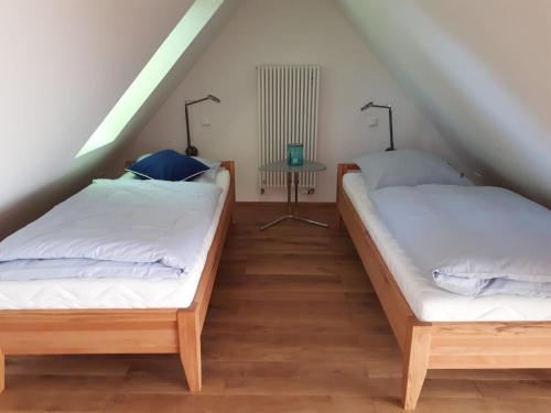 two beds in a attic room with a table at Kühlhouse in Loxstedt