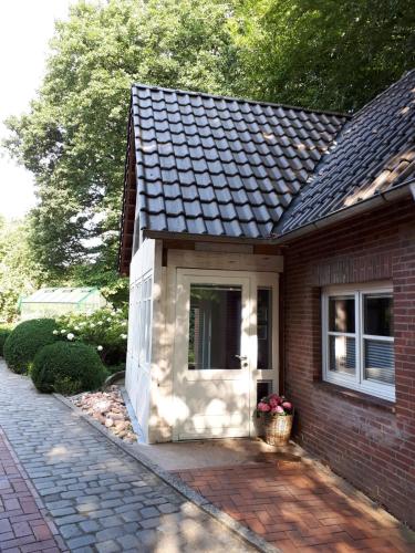 a small brick house with a window and a door at Kühlhouse in Loxstedt