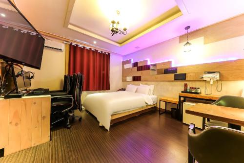 a hotel room with a bed and a desk and a computer at Manhatan Hotel 청주 in Cheongju