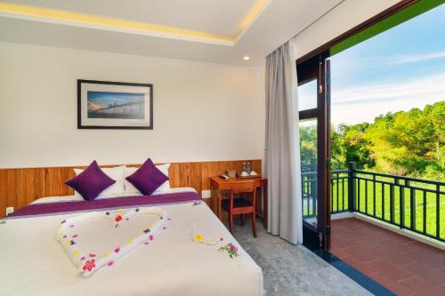 a bedroom with a bed and a balcony at Lama Villa Hoi An in Hoi An