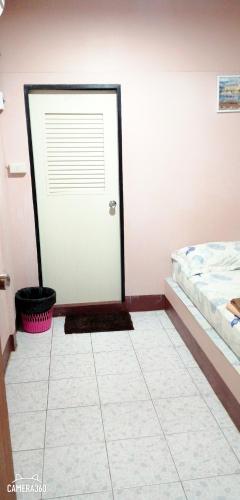 a bedroom with a white door and a bed at Canaan in Kanchanaburi