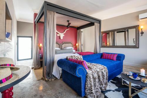 a living room with a blue couch and a bed at Etosha King Nehale in Omuthiya