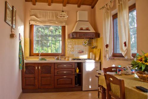 una cucina con frigorifero bianco e lavandino di Casale Dinelli a Tarquinia
