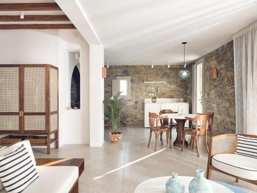 a living room and dining room with a table and chairs at Belvedere Mykonos - Hilltop Rooms & Suites - The Leading Hotels of the World in Mýkonos City