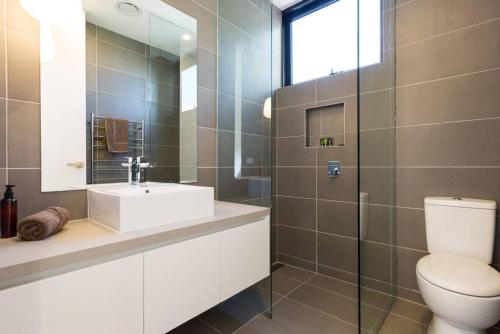 bagno con servizi igienici, lavandino e specchio di Lola Three Levels of Style with Rooftop Terrace a Melbourne