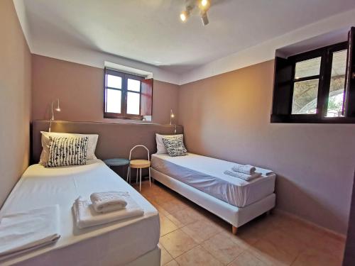 - une chambre avec 2 lits et une chaise dans l'établissement Anaroussa Diros Apartment, à Areópoli