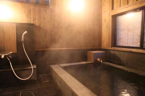 a bathroom with a bath tub with a shower at Ryokan Wakaba in Minamioguni