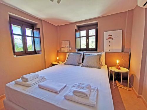 a bedroom with a large white bed with two towels on it at Anaroussa Diros Maisonette in Areopoli