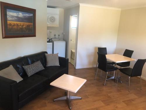 
a living room with a couch a table and a coffee table at Latitude20 Karratha Apartments in Karratha
