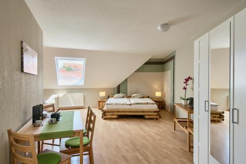 a bedroom with a bed and a table and a dining room at Ferienwohnungen "Am Waidweg" in Bad Langensalza