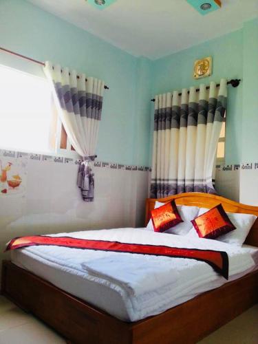 a bedroom with a bed with blue walls and a window at Hotel Hồng Hạc nha trang in Nha Trang