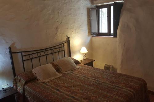 um quarto com uma cama num quarto com uma janela em Casa César em Jabugo