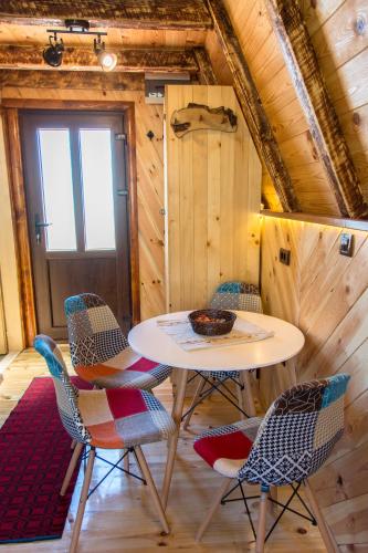 a room with a table and chairs and a door at Etno selo Smrčevo brdo in Žabljak