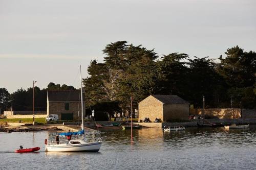 a small boat in the water next to a building at LE LOFT in Séné