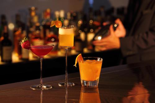 three cocktails sitting on a table in a bar at Kobe Meriken Park Oriental Hotel in Kobe