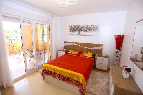 1 dormitorio con cama, escritorio y balcón en LUXURY GOLF RESORT by MM, en Torre-Pacheco