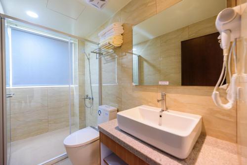 a bathroom with a sink and a toilet and a shower at Little Molly B&B in Magong
