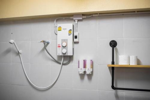 La salle de bains est pourvue d'une douche et d'un tuyau mural. dans l'établissement Hot Coffee Guest House and Resort, à Ban Mae Na Chon