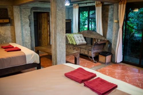 - une chambre avec 2 lits et des serviettes rouges dans l'établissement Hot Coffee Guest House and Resort, à Ban Mae Na Chon