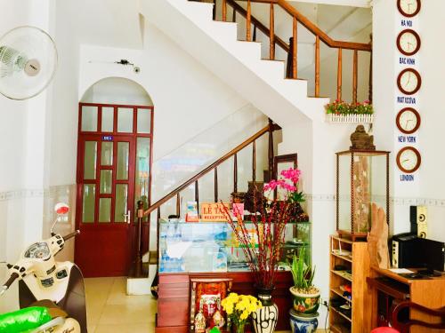 un corridoio con scala con fiori in un negozio di Hotel Hồng Hạc nha trang a Nha Trang