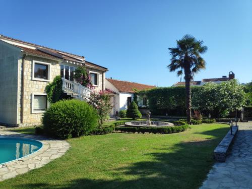 a house with a palm tree and a swimming pool at Leisure House Jovovic in Bar