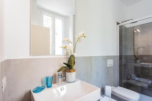 a white bathroom with a sink and a toilet at Amazing Cernobbio - Lake Como by Rent All Como in Cernobbio