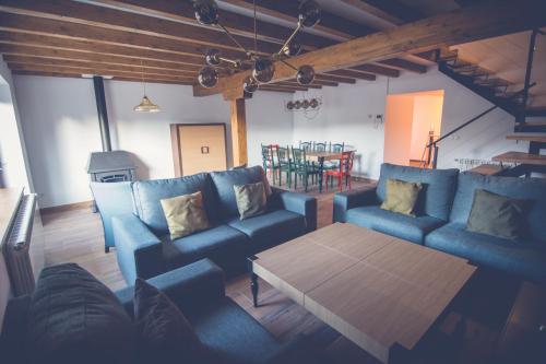 una sala de estar con sofás azules y una mesa. en Palomba Rural, en Espinilla