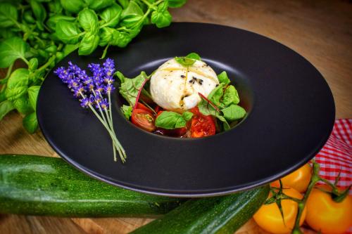 a plate of food on a table with vegetables at Parkhotel Surenburg in Hörstel