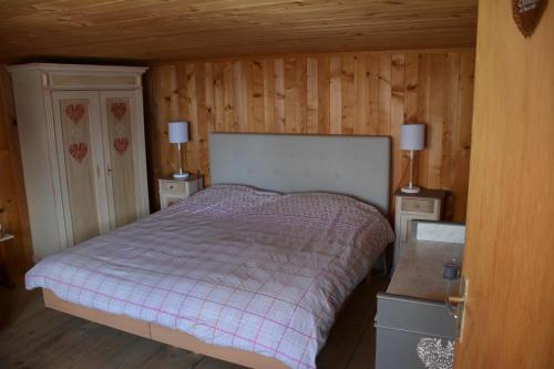 um quarto com uma cama com duas mesas de cabeceira e dois candeeiros em Chalet Beau Site em Le Sépey