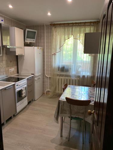 トゥーラにあるApartment Gogolevskayaのキッチン(テーブル付)、キッチン(白い家電製品付)