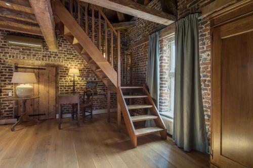 
a wooden staircase leading up to a room with a wooden floor at Hotel Kasteel Terworm in Heerlen
