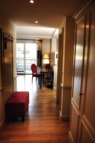 a hallway with a room with a desk and a red chair at Parkhotel Surenburg in Hörstel