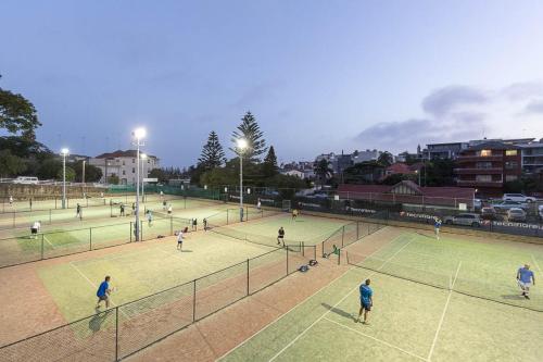 a group of people playing tennis on a tennis court at Stylish and Spacious Beach Apartment in Sydney