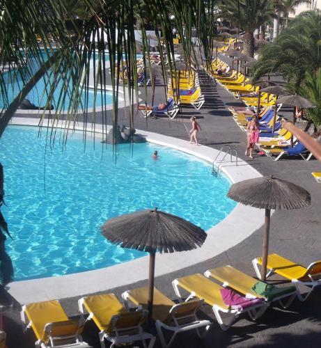 a large swimming pool with chairs and umbrellas at Hotel Beatriz Playa & Spa in Puerto del Carmen