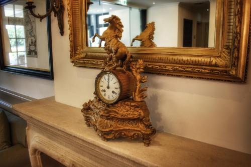 a clock sitting on a table in front of a mirror at Parkhotel Surenburg in Hörstel
