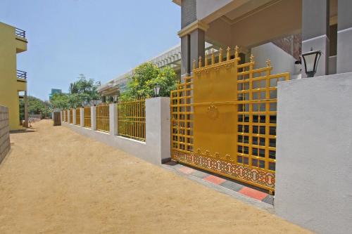 a yellow gate on the side of a building at VLS Holiday Home in Kanyakumari