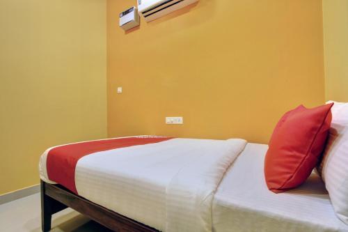 a bedroom with a bed with a red pillow on it at VLS Holiday Home in Kanyakumari