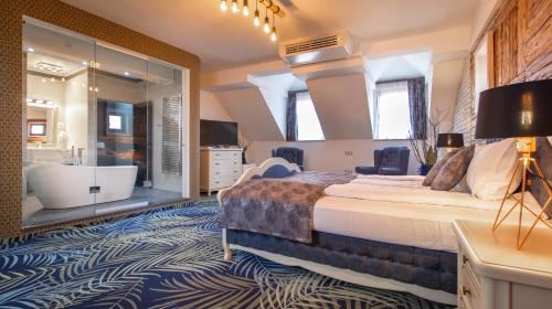 a bedroom with a large bed and a bath tub at ART Hotel in Sibiu