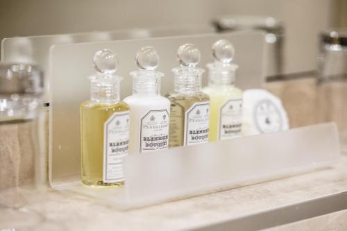a group of four bottles of oils sitting on a counter at Claremont Hotel in Douglas