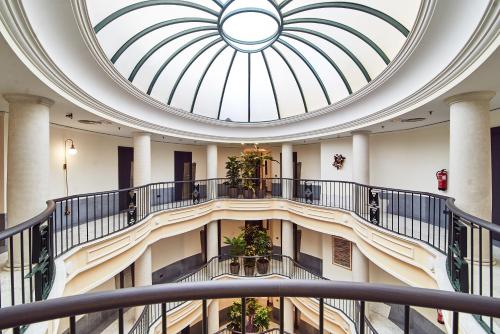 a spiral staircase in a building with a skylight at Occidental León Alfonso V in León