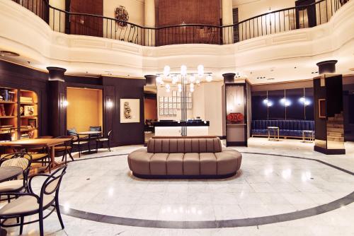 a lobby with a couch in the middle of a room at Occidental León Alfonso V in León