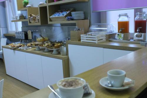 a kitchen with cups of coffee on a counter at Hotel Gran Sasso & SPA in Teramo