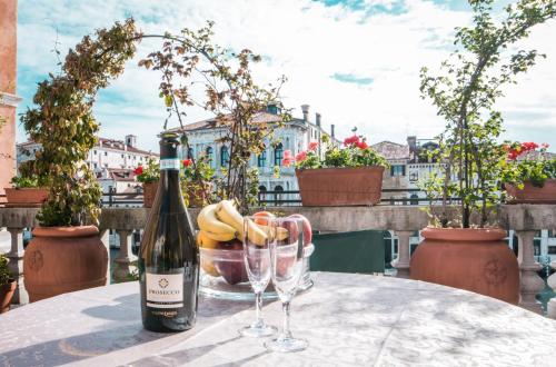 Una botella de vino y dos copas en una mesa. en Ca Zulian Venice - Grand Canal, en Venecia