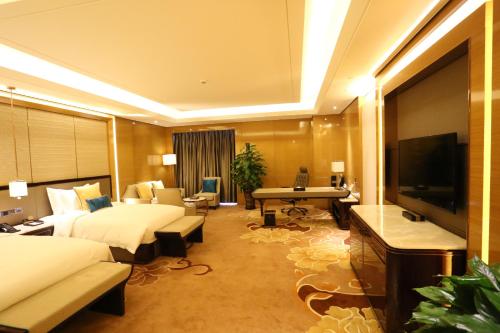 a hotel room with two beds and a flat screen tv at JinJiang International Hotel Urumqi in Ürümqi