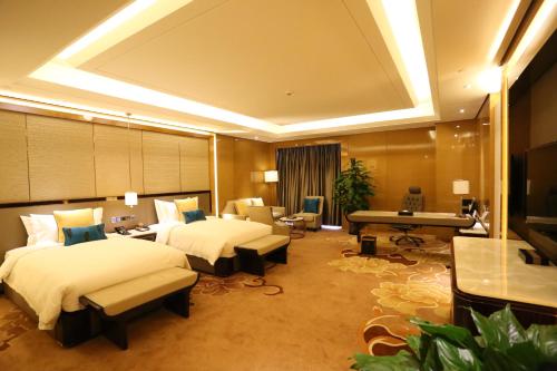 a hotel room with two beds and a piano at JinJiang International Hotel Urumqi in Ürümqi